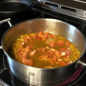 Ajouter le bouillon et le jus de citron et les tomates, faire mijoter quelques minutes.